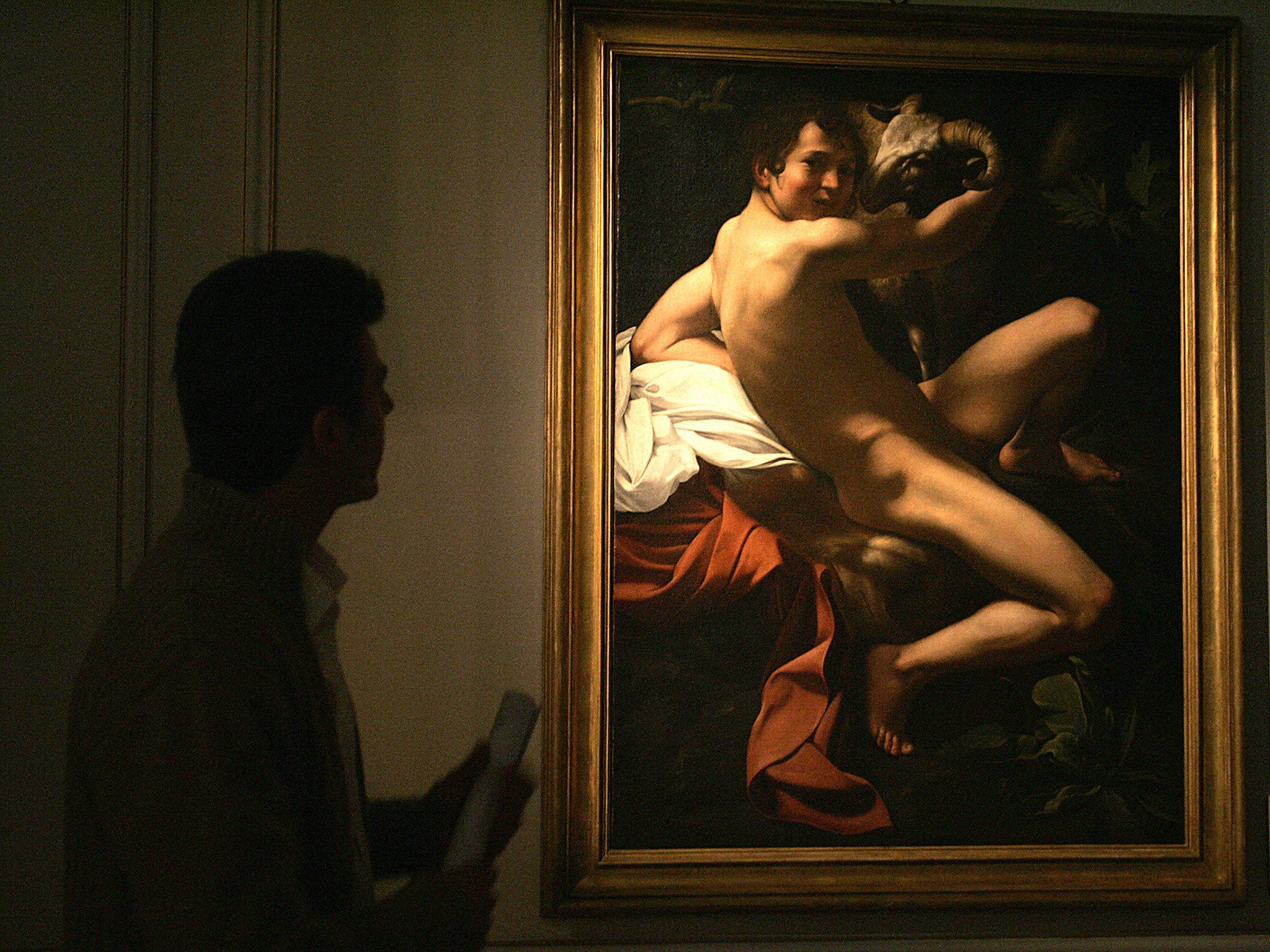 A visitor looks at 'Saint John the Baptist', a 17th century painting originally attributed to Michelangelo Merisi da Caravaggio, on display at Athens' Museum of Cycladic Art 27 April 2006.