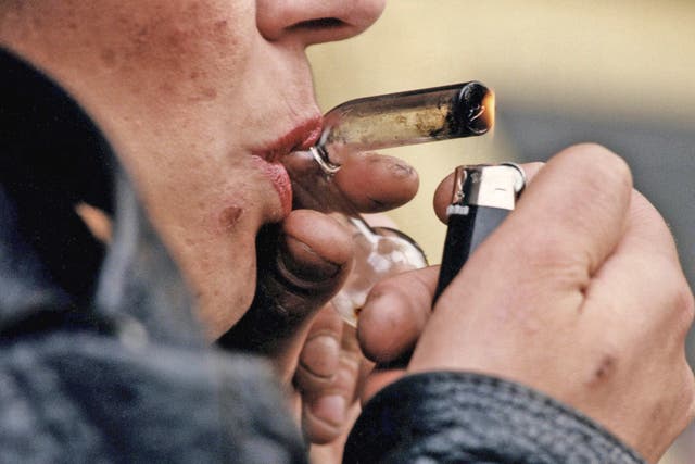 A drug addict smoking a crack pipe