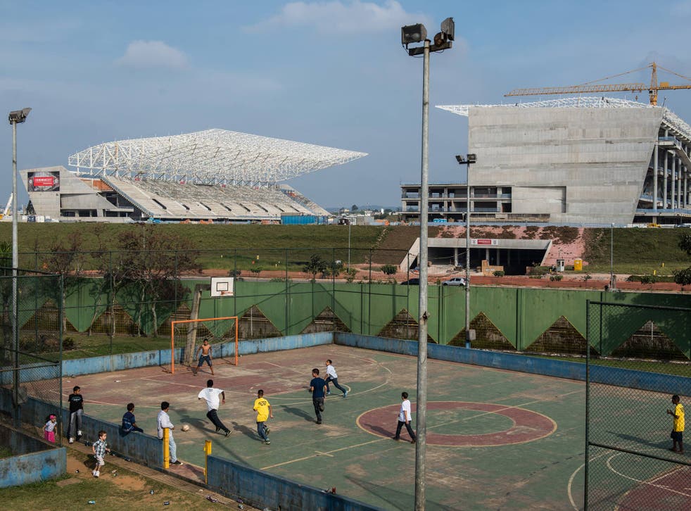 Children play football near the Itaquerao Stadium (Corinthians Arena) in Sao Paulo, the venue for the opening match of the World Cup