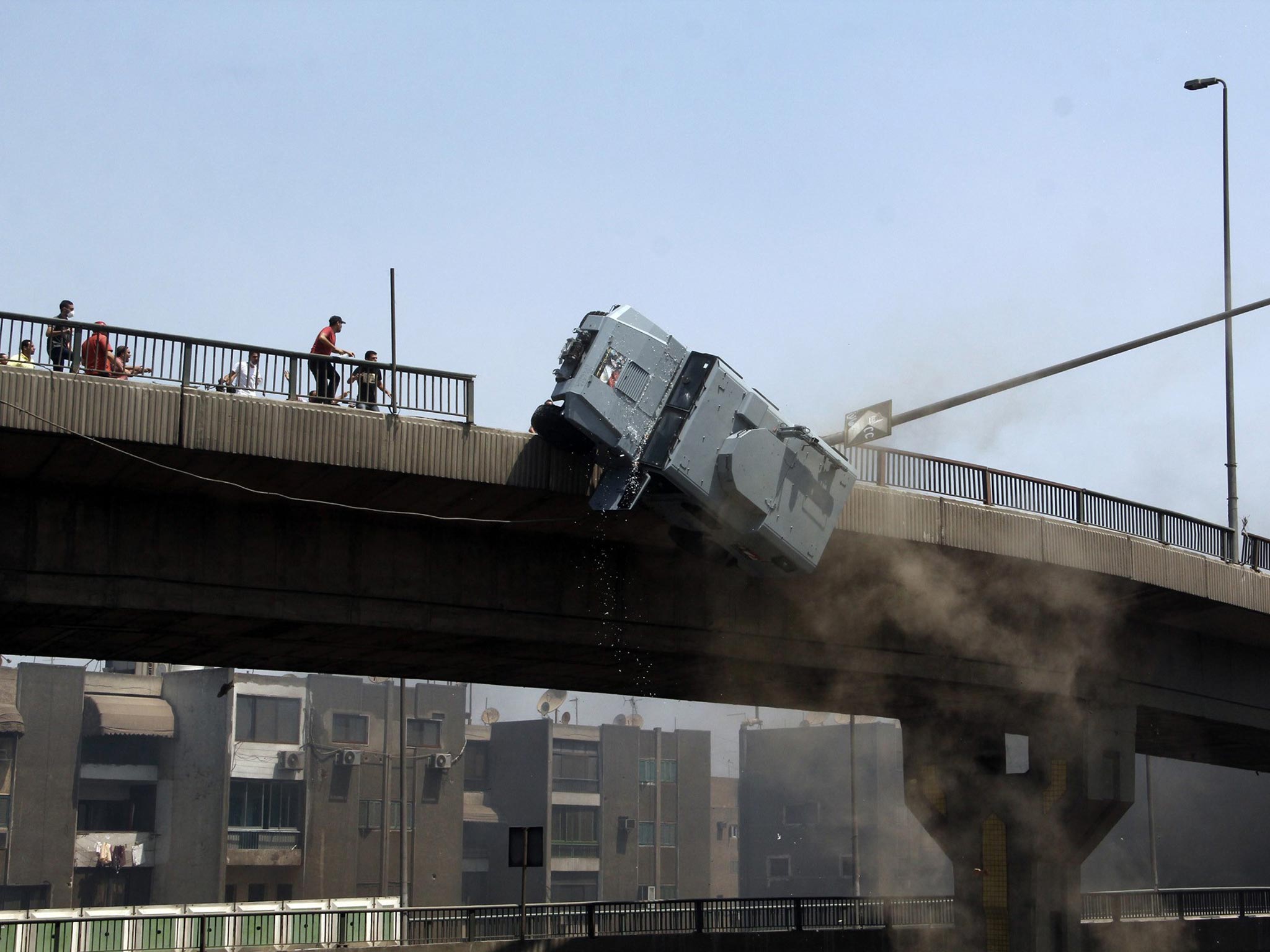 A police vehicle is pushed off the 6th of October bridge by protesters close to the largest sit-in by supporters of ousted Islamist President Mohammed Morsi in the eastern Nasr City district of Cairo, Egypt