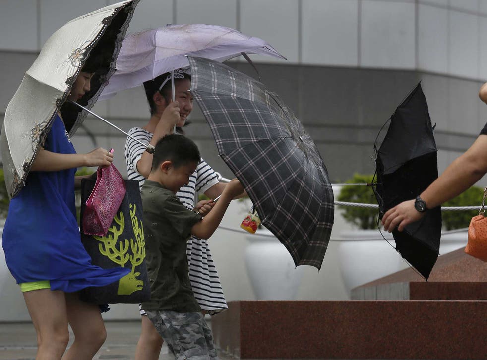 Tourists battle against strong wind near the waterfront in Hong Kong