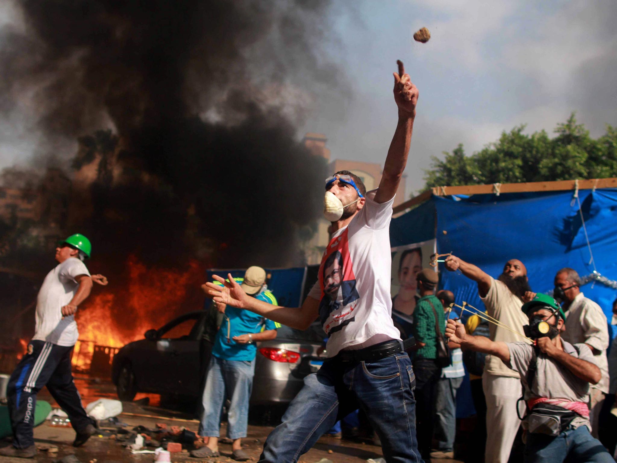 Egyptian protesters throw rocks at security forces during the clearing of one of the two sit-ins of ousted president Morsi supporters, near Rabaa Adawiya mosque, Cairo