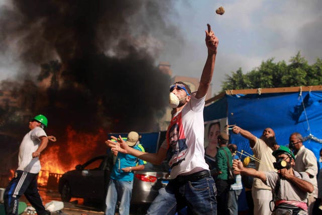 Egyptian protesters throw rocks at security forces during the clearing of one of the two sit-ins of ousted president Morsi supporters, near Rabaa Adawiya mosque, Cairo