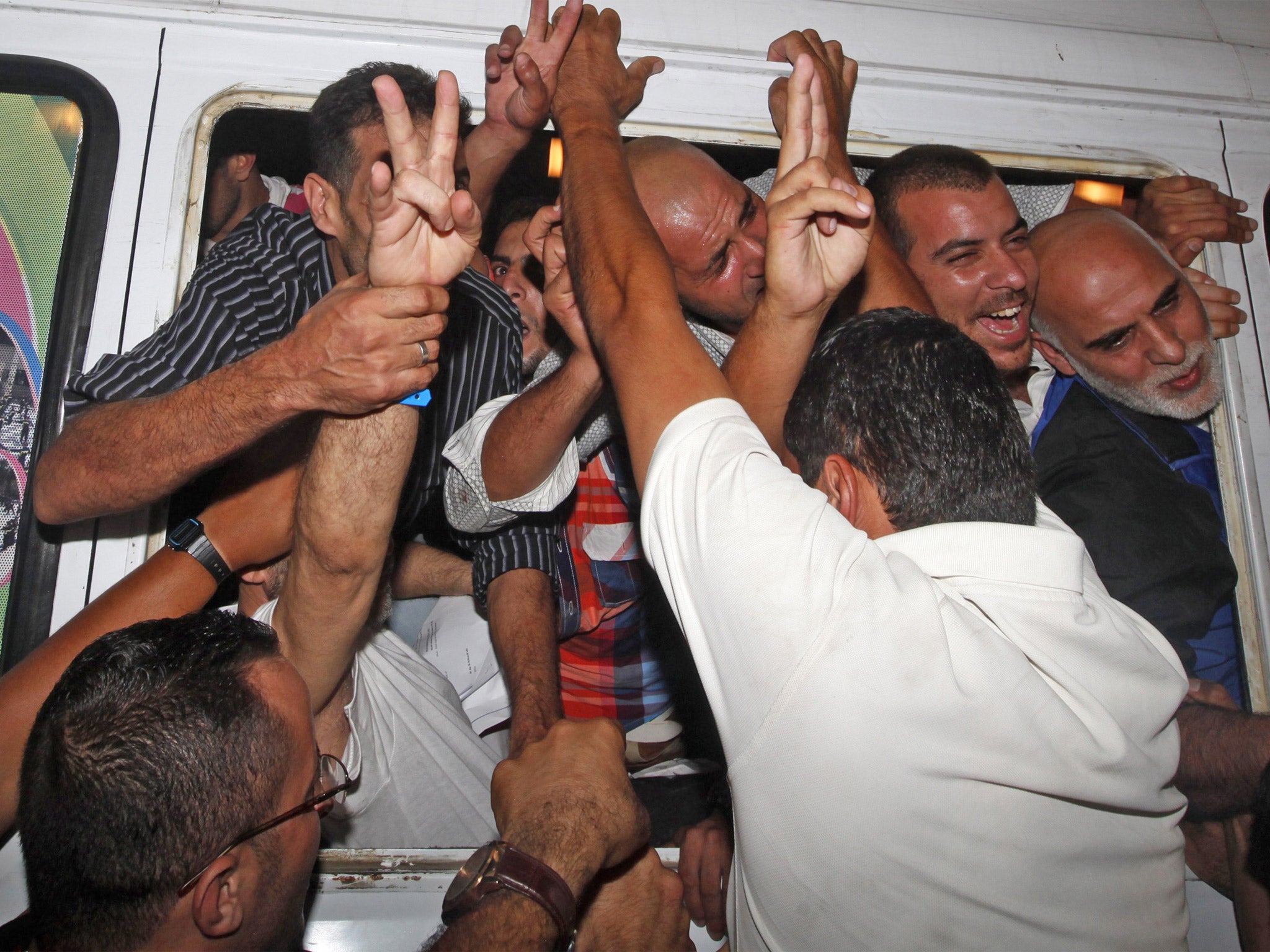 Relatives jump to a vehicle carrying the freed men