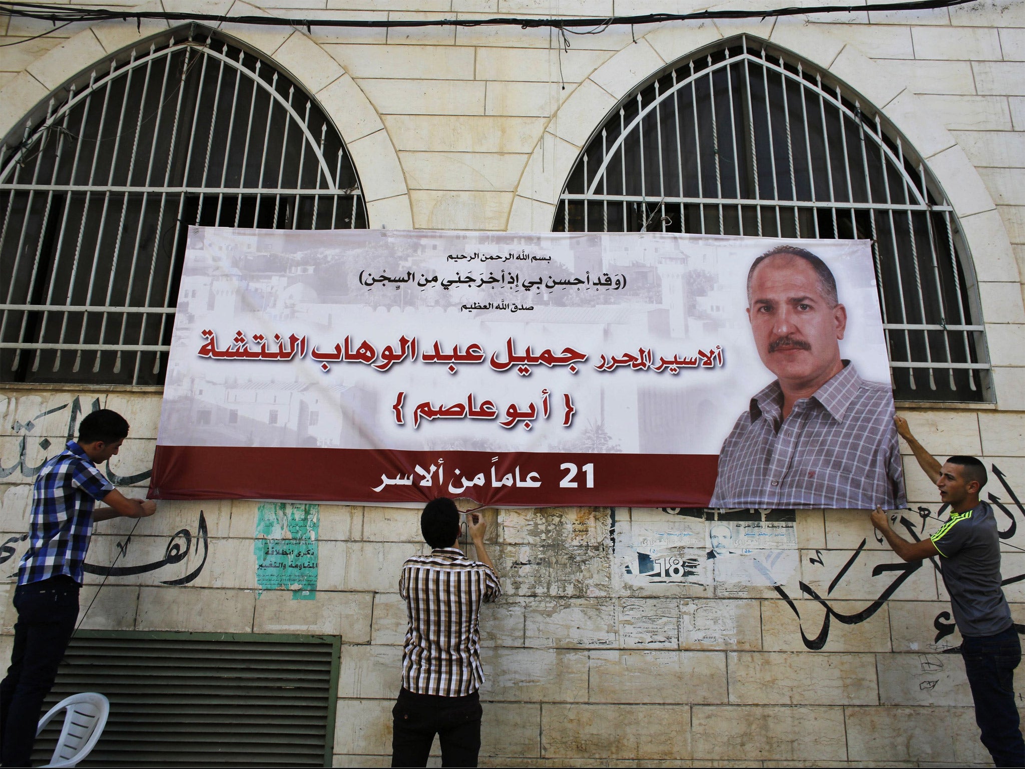 Relatives hang a banner depicting freed prisoner Jamil Nabi Annatsheh outside his house