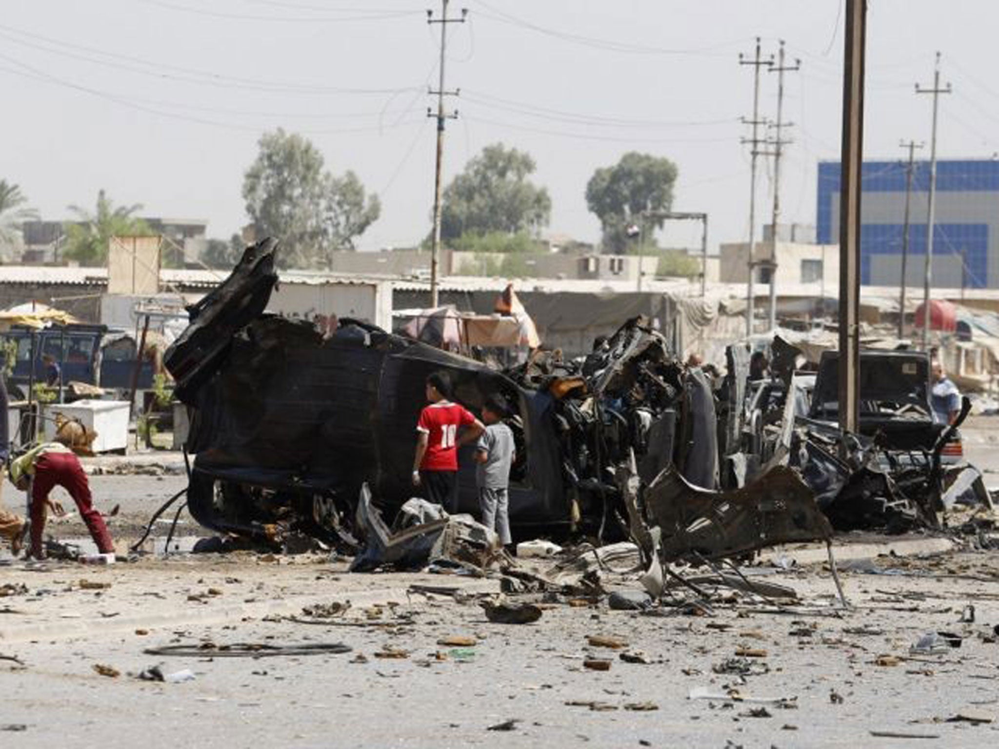 People gather at the site of a car bomb attack in Baghdad, 15 August, 2013. Five car bombs in Baghdad killed at least 23 people on Thursday and wounded more than 80, Iraqi police sources said.