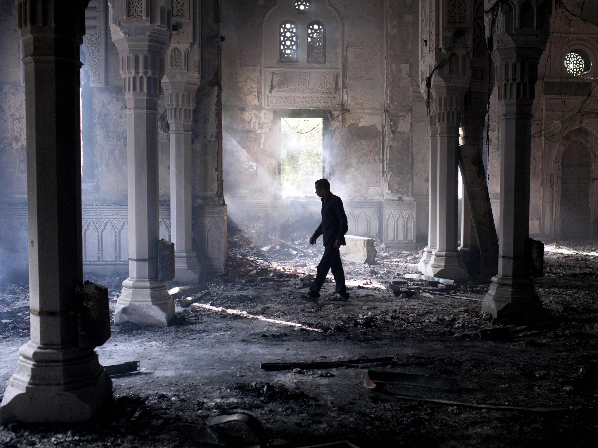 A man walks inside the burnt out Rabaa Adawiya mosque, the morning after the clearing of the sit-in which was held in and around the mosque in Cairo, Egypt