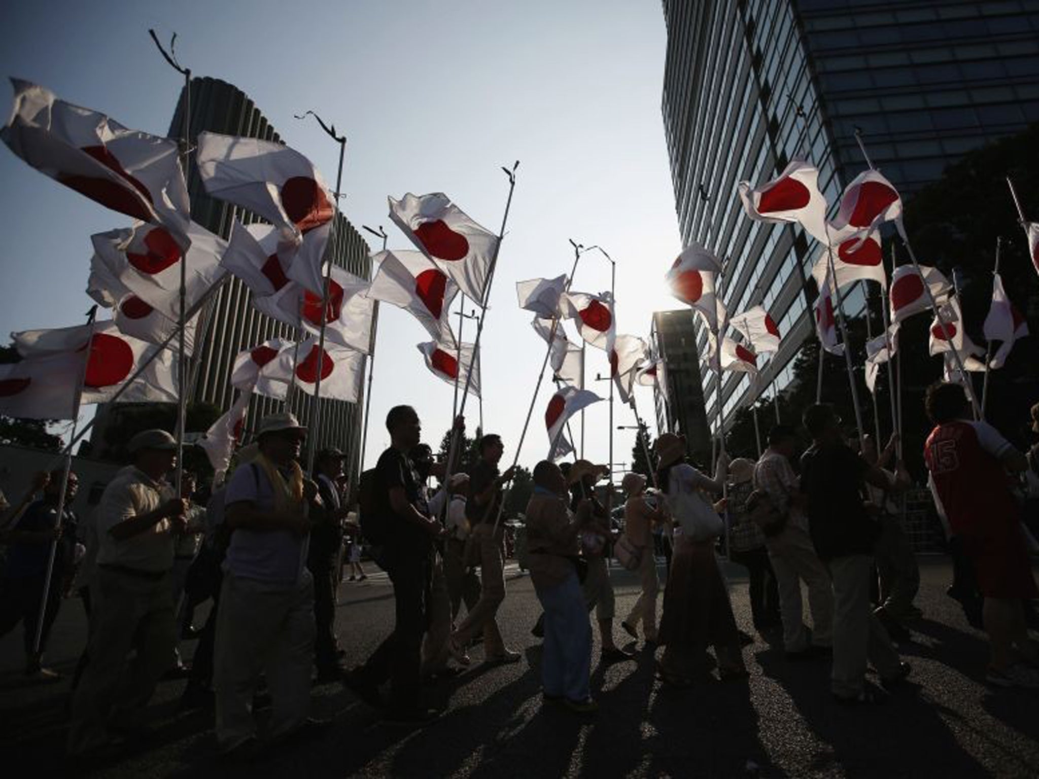 Members of nationalist movement 'Ganbare Nippon' march with Japanese national flags while paying tribute to the war dead near Yasukuni Shrine