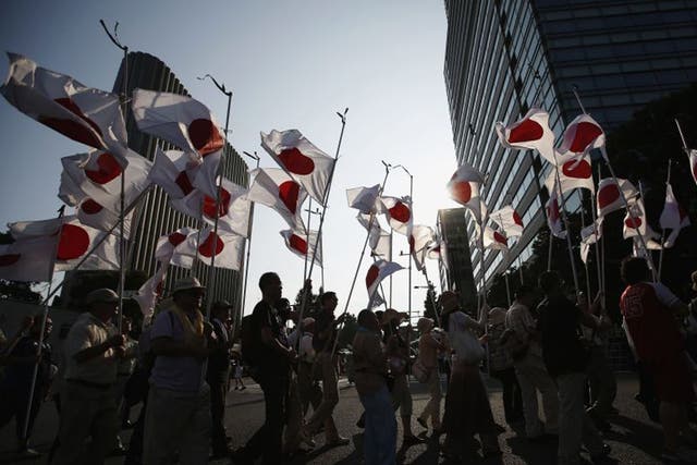 Members of nationalist movement 'Ganbare Nippon' march with Japanese national flags while paying tribute to the war dead near Yasukuni Shrine