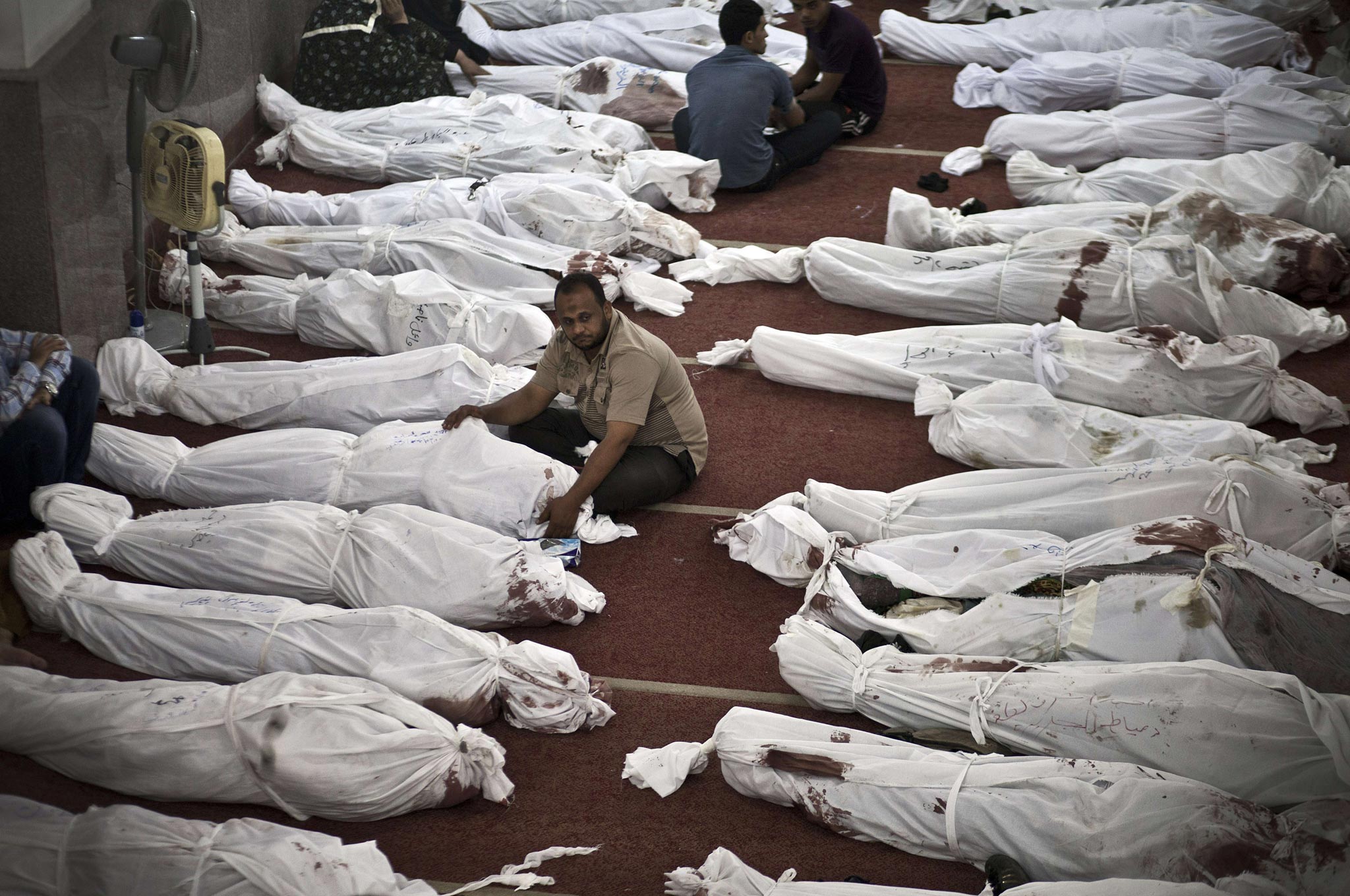 Egyptians mourn over bodies wrapped in shrouds at a mosque