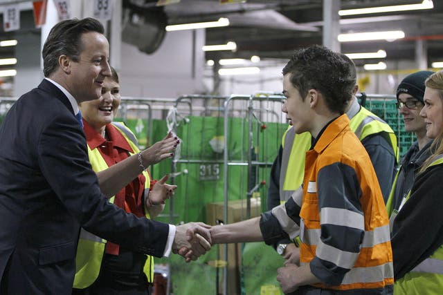 David Cameron shakes hands with a young apprentice  during a visit to Waitrose