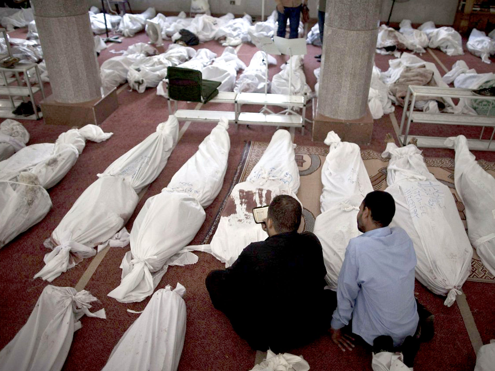 Egyptians mourn over bodies wrapped in shrouds at a mosque in Cairo on 15 August 2013