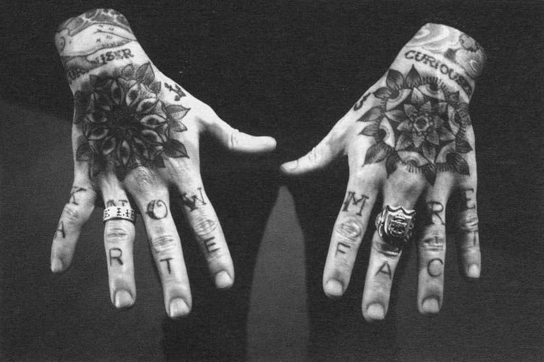 Matt's hands, tattooed with the words 'KNOW MORE' and 'ARTEFACT', in honour of his profession