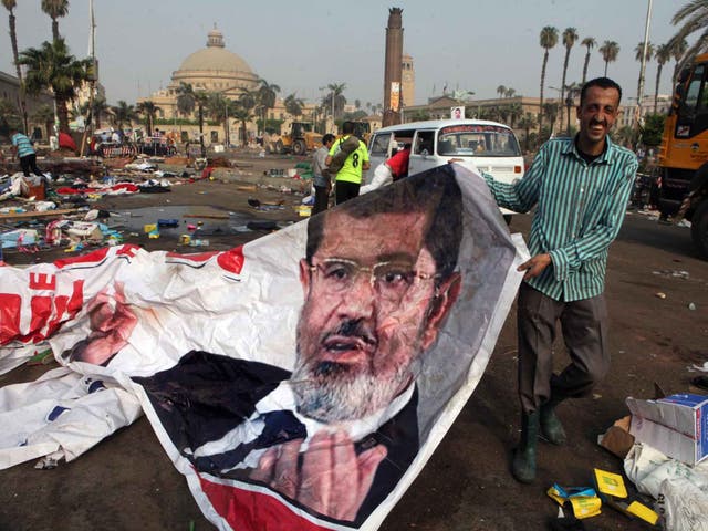 An Egyptian holds up a banner of Egypt’s ousted President Mohamed Morsi in Cairo