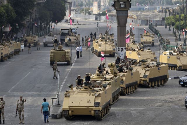 Egyptian army soldiers take their positions on top and next to their armored vehicles while guarding an entrance to Tahrir square, in Cairo, Egypt, Friday, Aug. 16, 2013