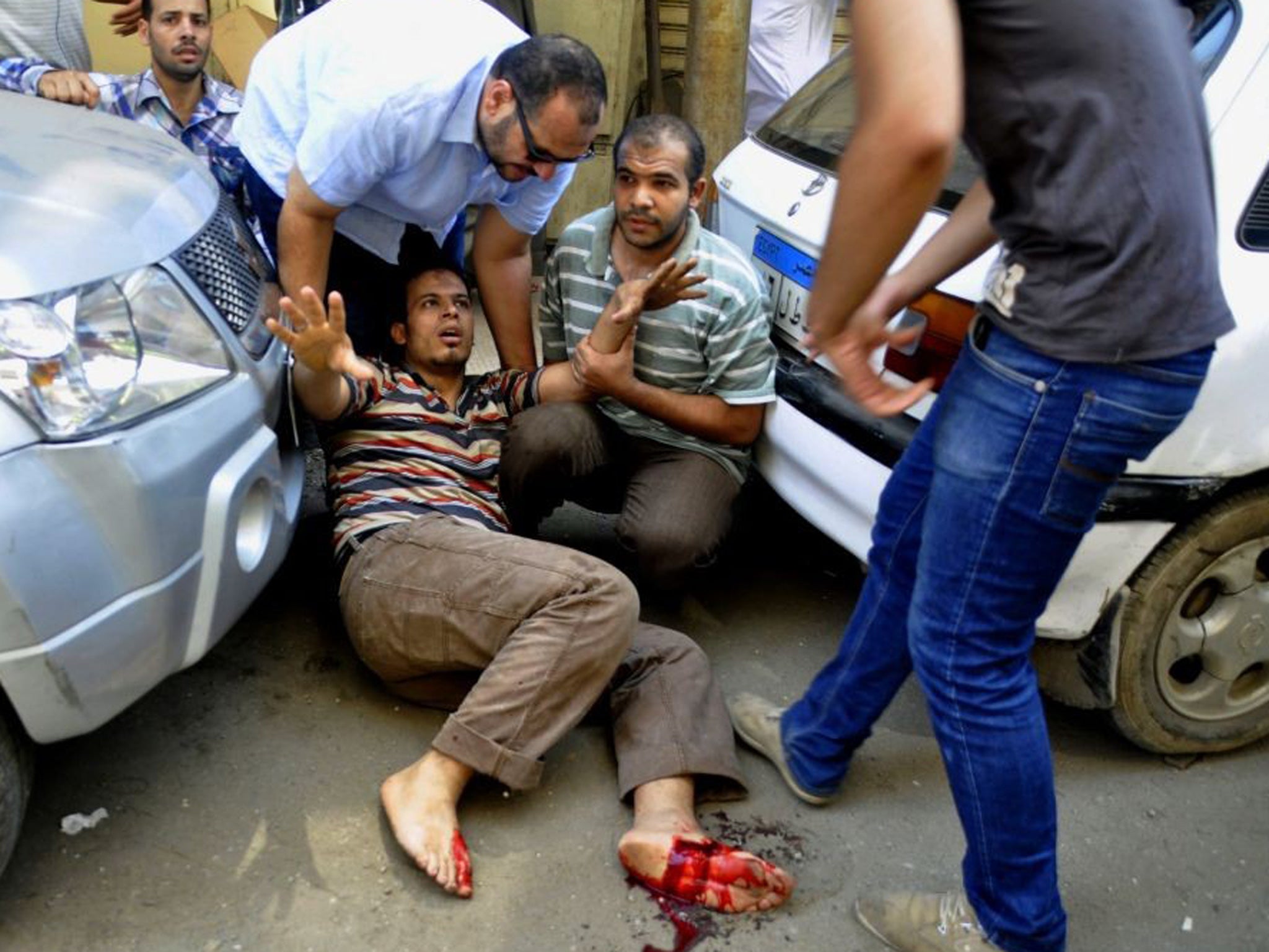 An Egyptian protester lies wounded after a Muslim Brotherhood protest approached a church protected by the army in Giza, Egypt on 16 August 2013
