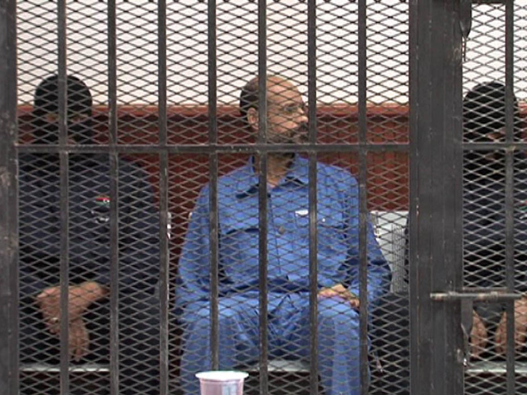 Saif al-Islam Gaddafi in a defendant’s cage in a courtroom in Zintan