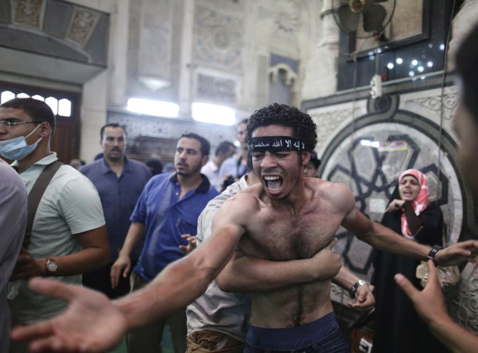 Egyptians mourn over the bodies of their relatives in the Al-Fath mosque