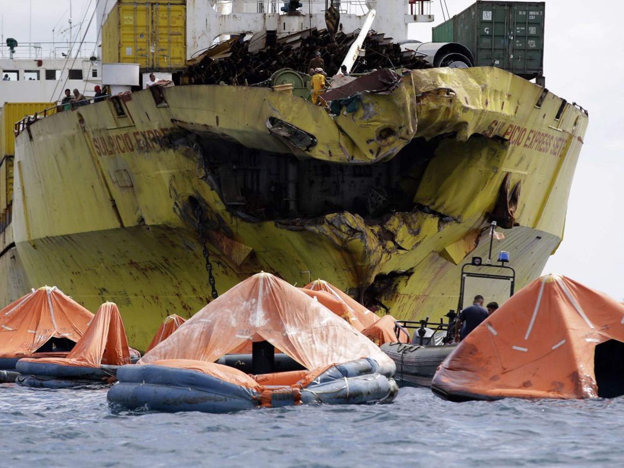 A cluster of life rafts floats near the cargo ship Sulpicio Express Siete Saturday Aug. 17, 2013, a day after it collided with a passenger ferry