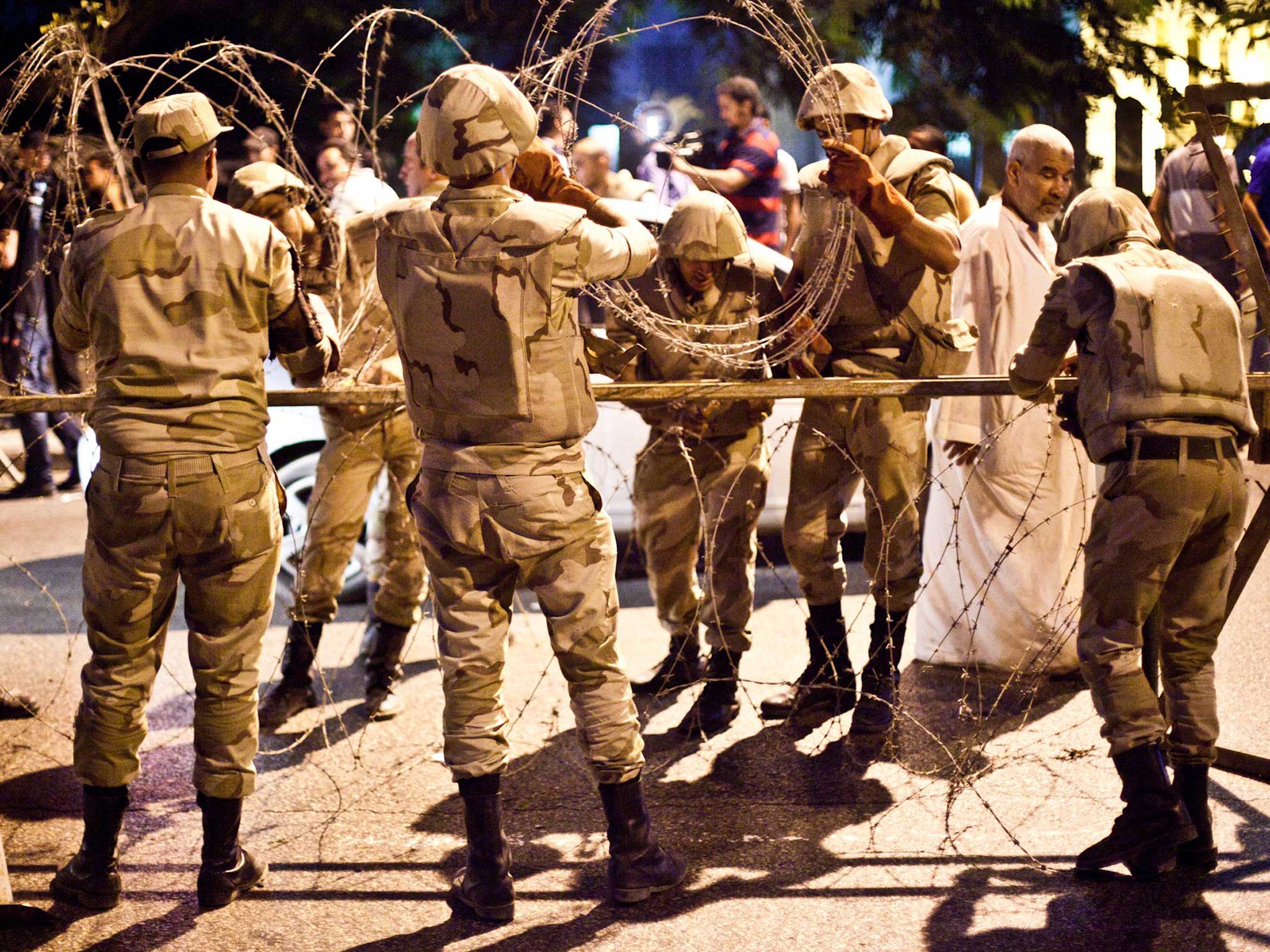 Egyptian army soldiers take out barbed wire that was surrounding the Supreme Constitutional Court in Cairo ahead of planned demonstrations yesterday