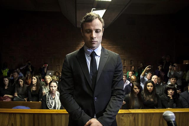 Murder accused Oscar Pistorius (C) appears in the Pretoria Magistrates court in Pretoria, South Africa