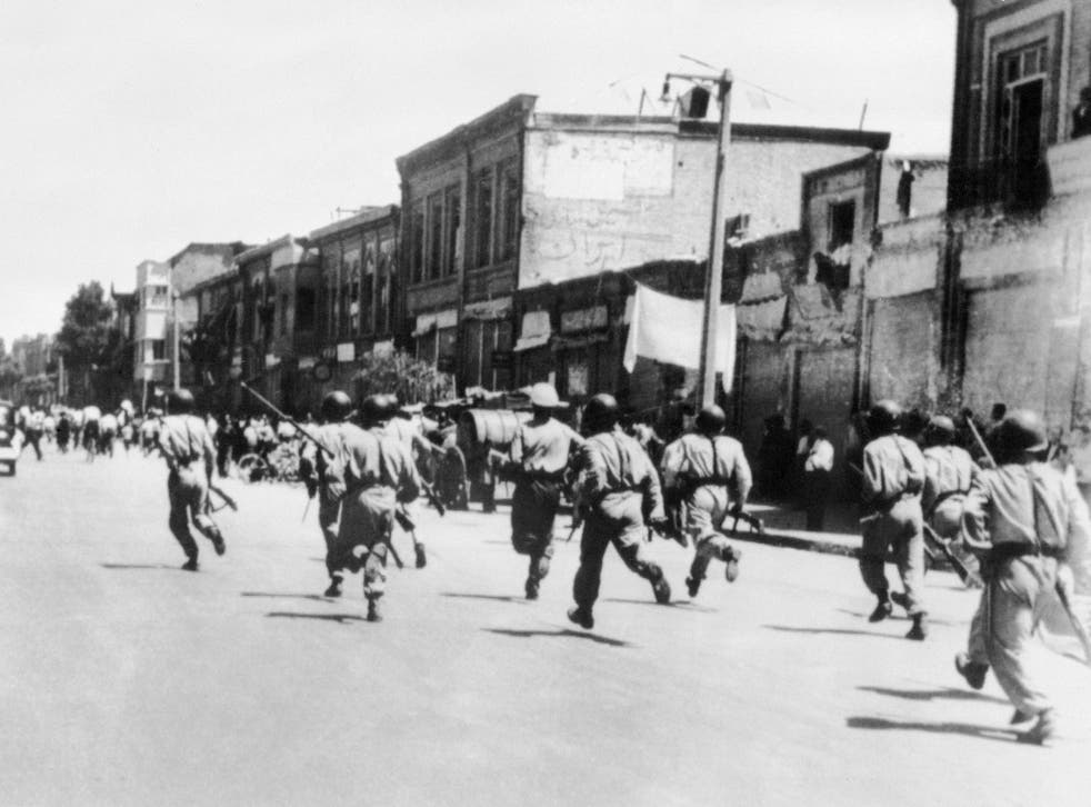 Persian soldiers chase rioters during civil unrest in Tehran, August 1953