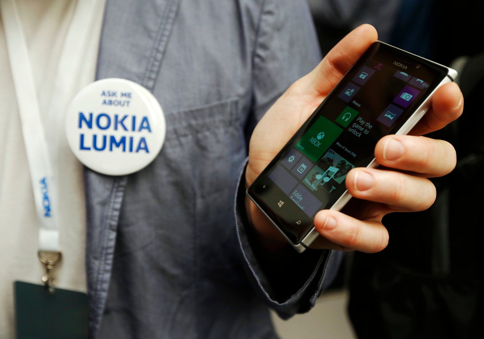 A worker poses with the new Nokia Lumia 925 at its launch in London May 14, 2013. Nokia unveiled a lighter, metal model in its Lumia smartphone range, as it tries to catch the eye of buyers to close the huge market lead of rivals Samsung and Apple Inc in