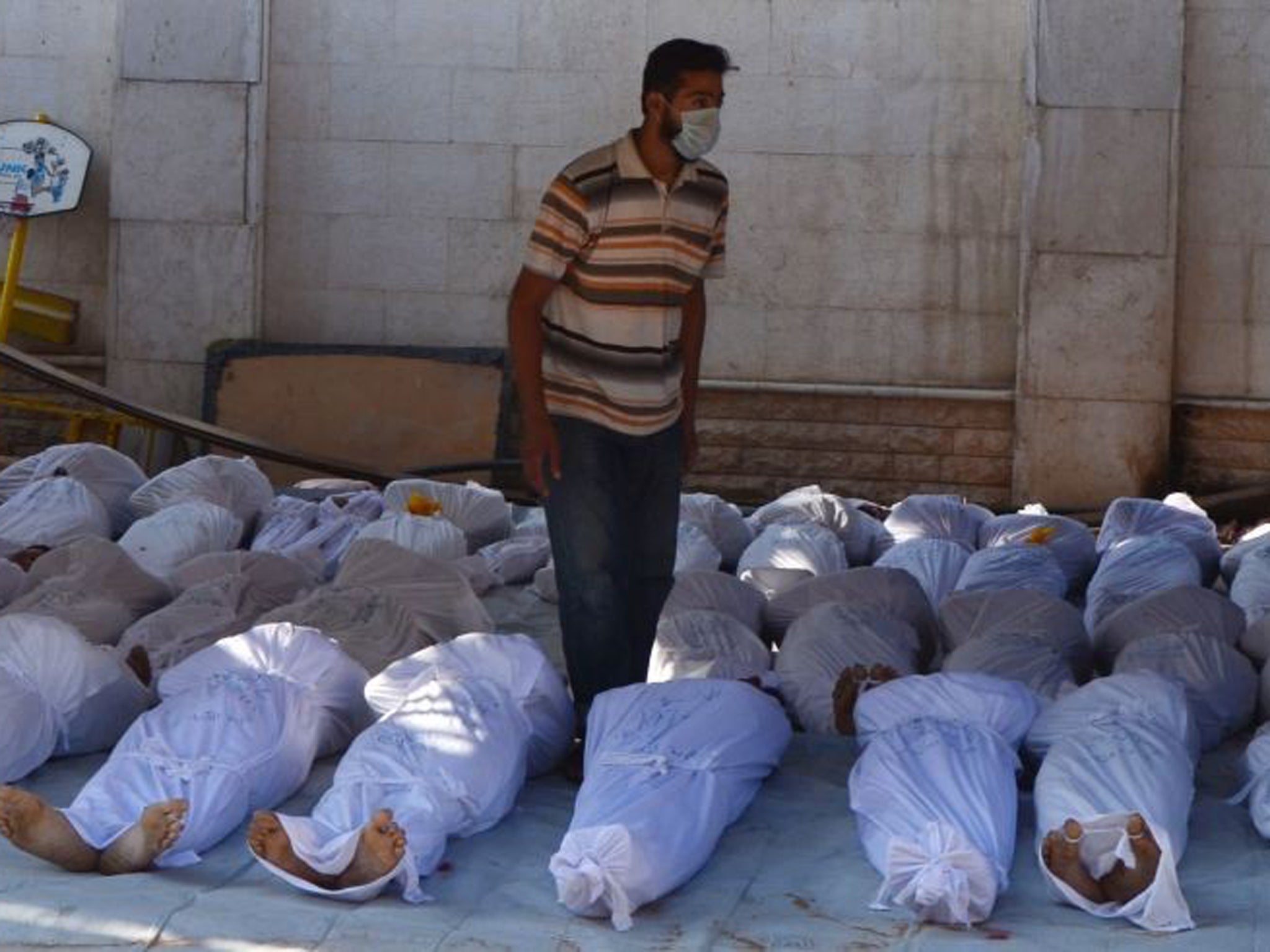 Syrian activists inspect the bodies of people they say were killed by nerve gas in the Ghouta region