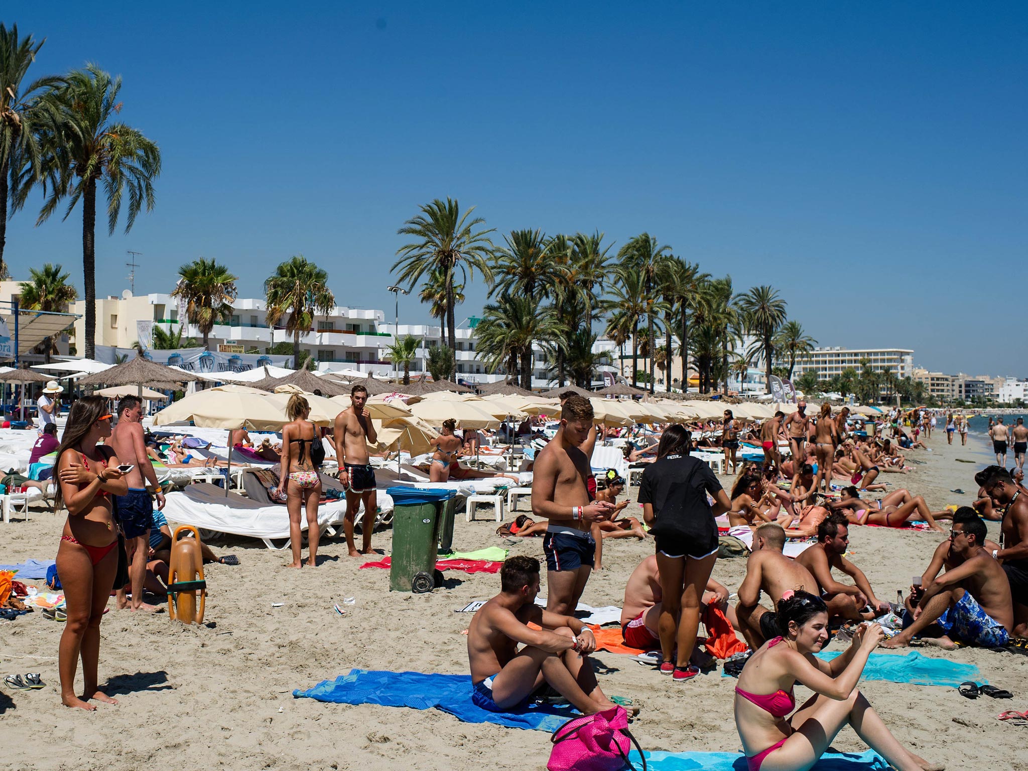 People sunbathe at Platja d'en Bossa beach in Ibiza, Spain
