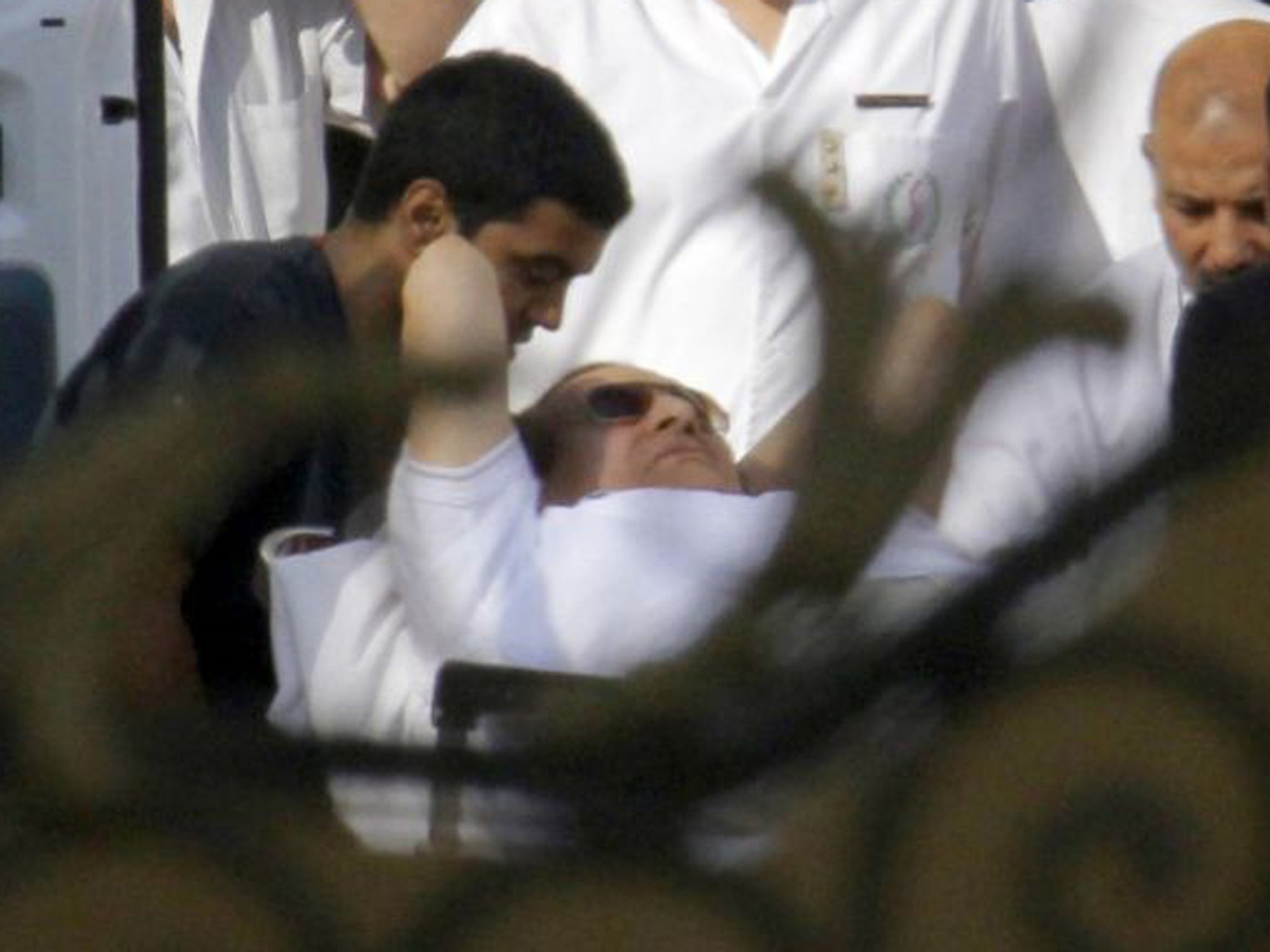 Egyptian medics escort Mubarak into an ambulance after he was flown by a helicopter ambulance to the Maadi Military Hospital from Torah prison in Cairo