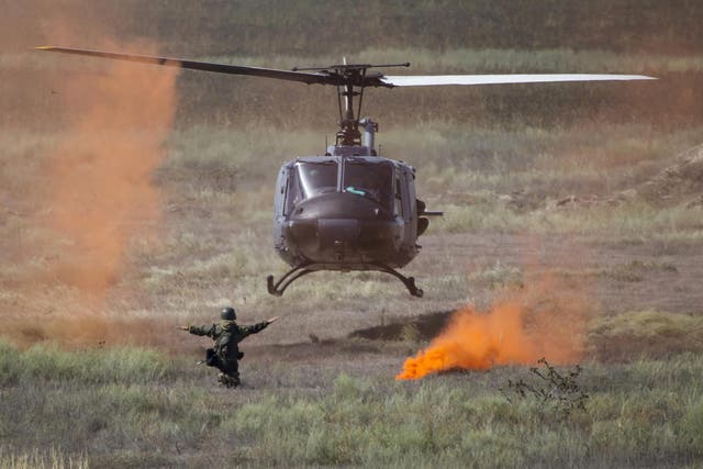 A soldier of Kazakhstan's Kazbrig brigade directs a landing Air Force Huey II helicopter during the Steppe Eagle international tactical military exercise at the Ili military range outside Almaty