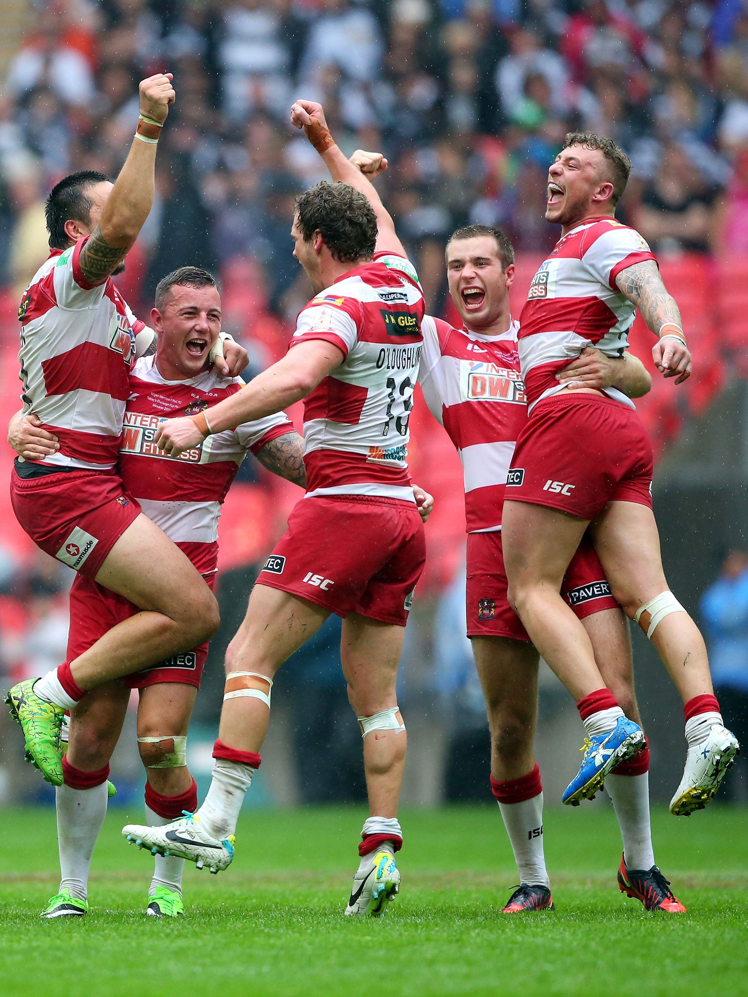 Jig of joy: Wigan players celebrate as the final whistle confirms victory