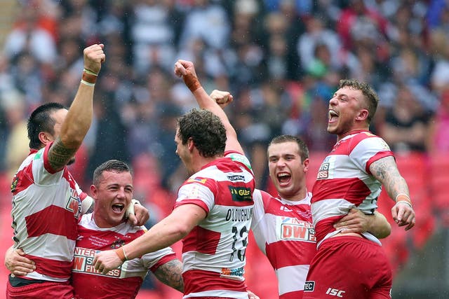 Jig of joy: Wigan players celebrate as the final whistle confirms victory