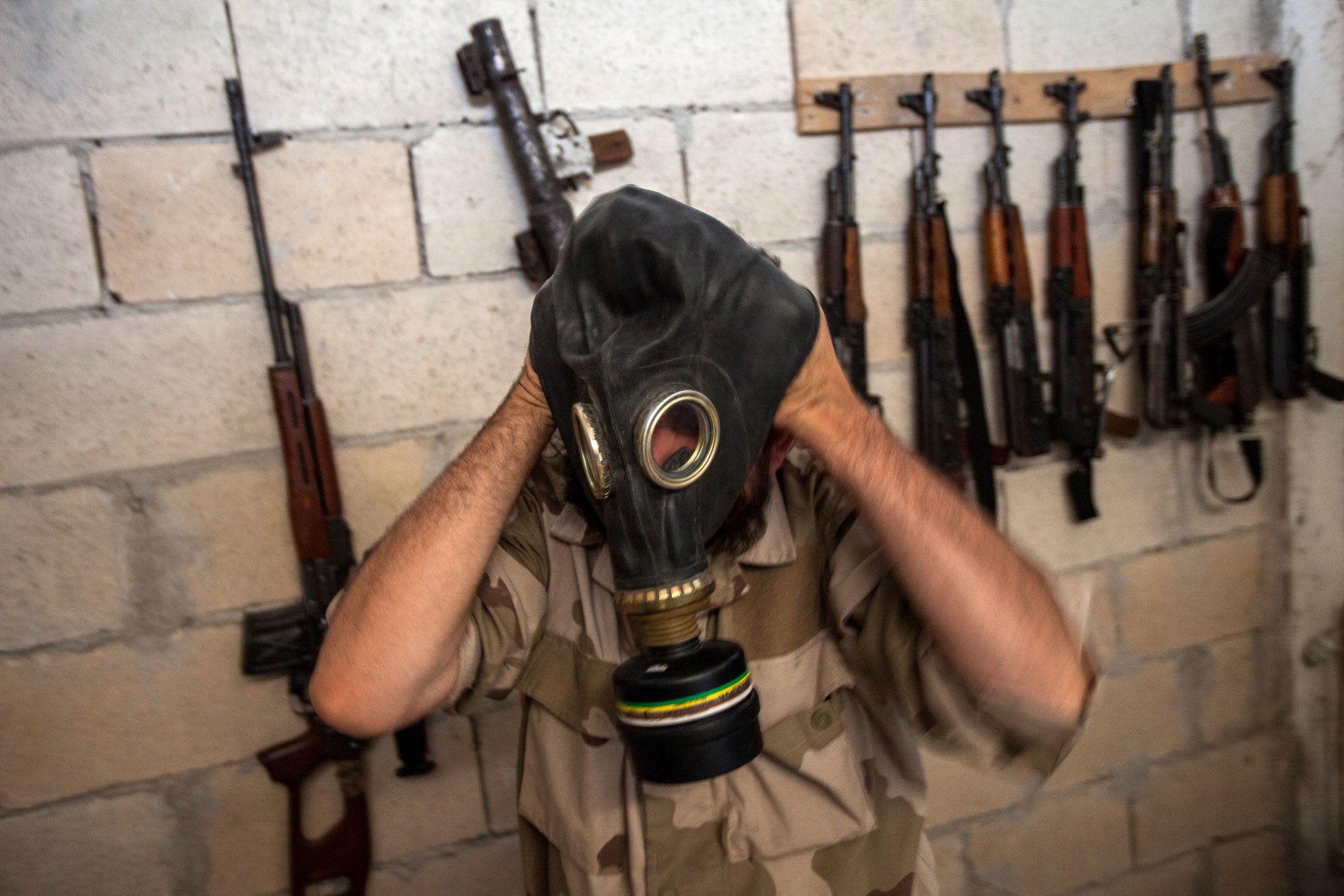 A Syrian rebel tries on a gas mask