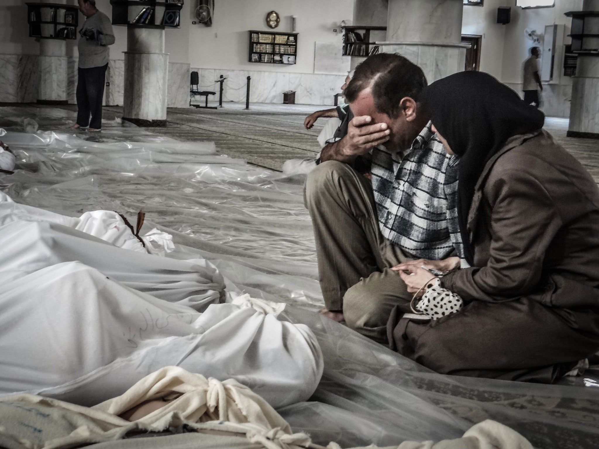 Parents grieve over the body of their child killed in a suspected chemical attack in Damascus