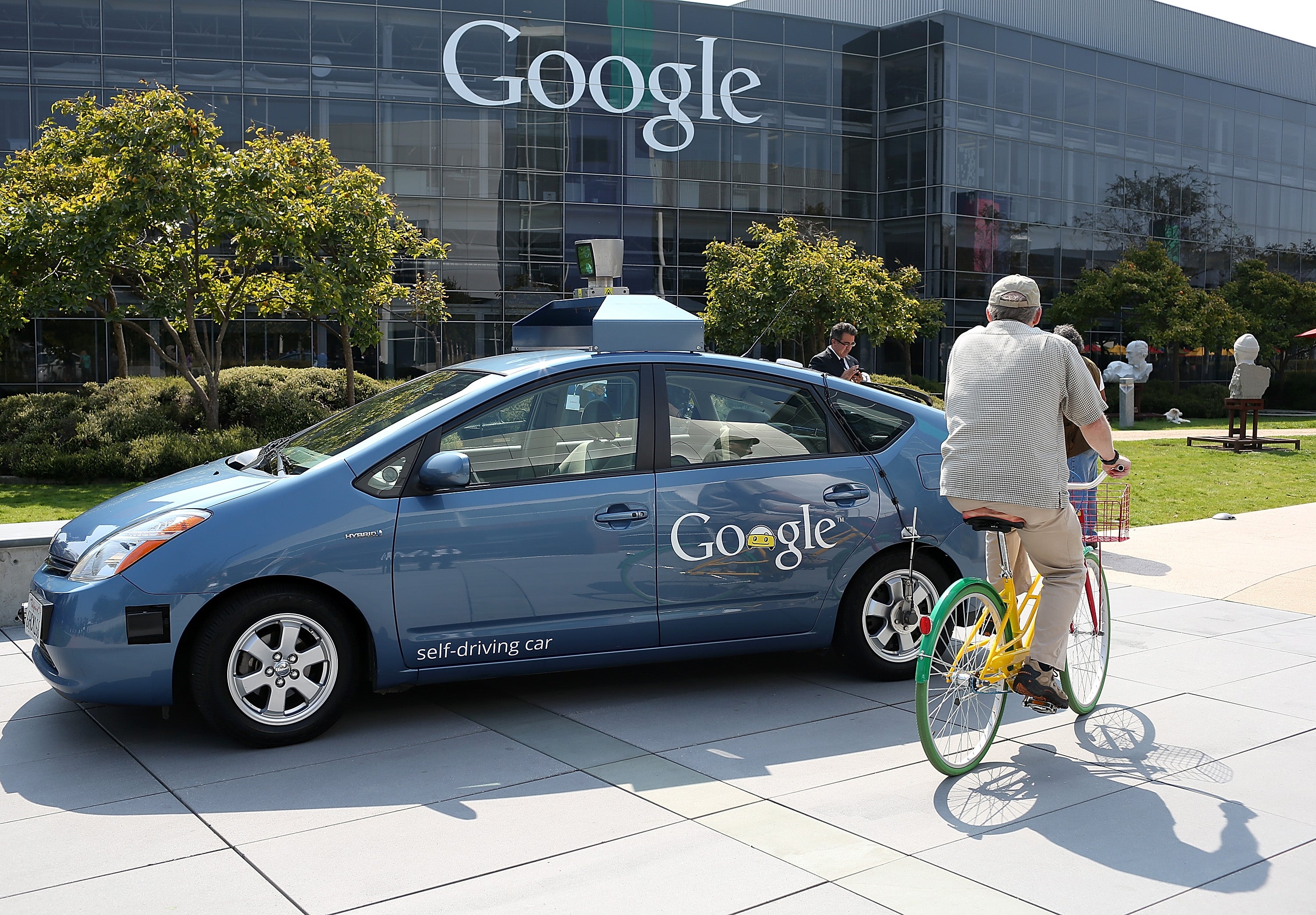 A bicyclist rides by a Google self-driving car at the Google headquarters on September 25, 2012 in Mountain View, California. California Gov. Jerry Brown signed State Senate Bill 1298 that allows driverless cars to operate on public roads for testing pur