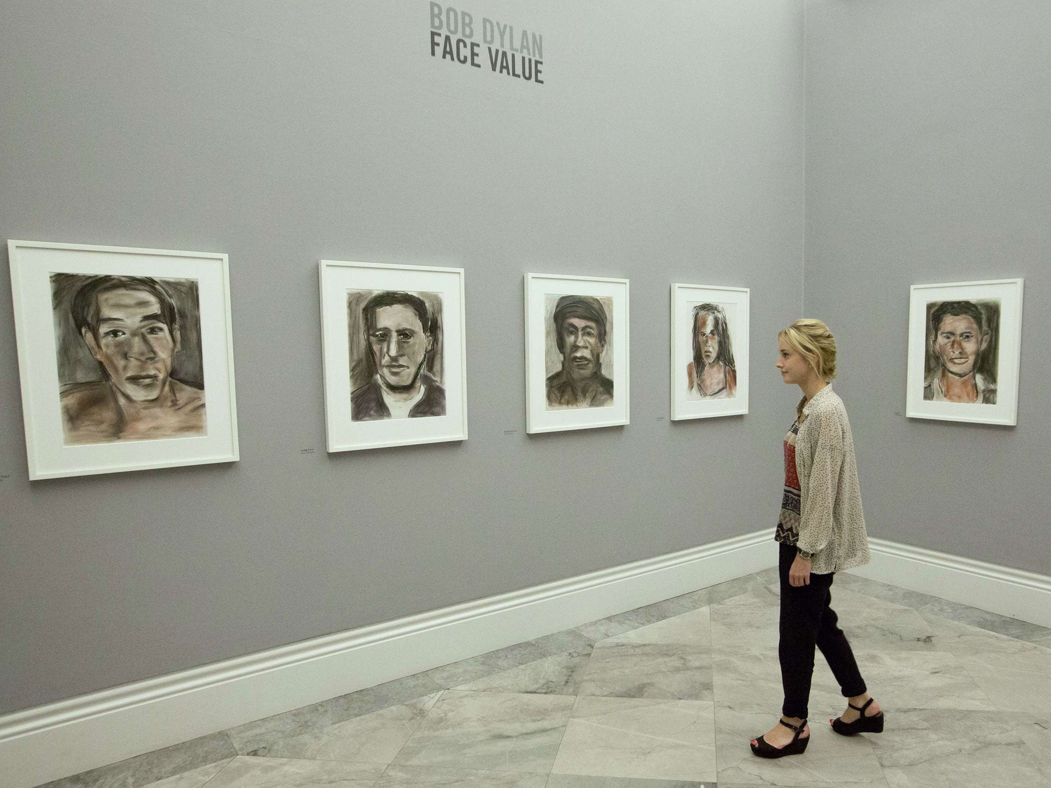 A gallery assistant views part of Bob Dylan's new body of work which includes the singer/artist's impression of Nina Felix