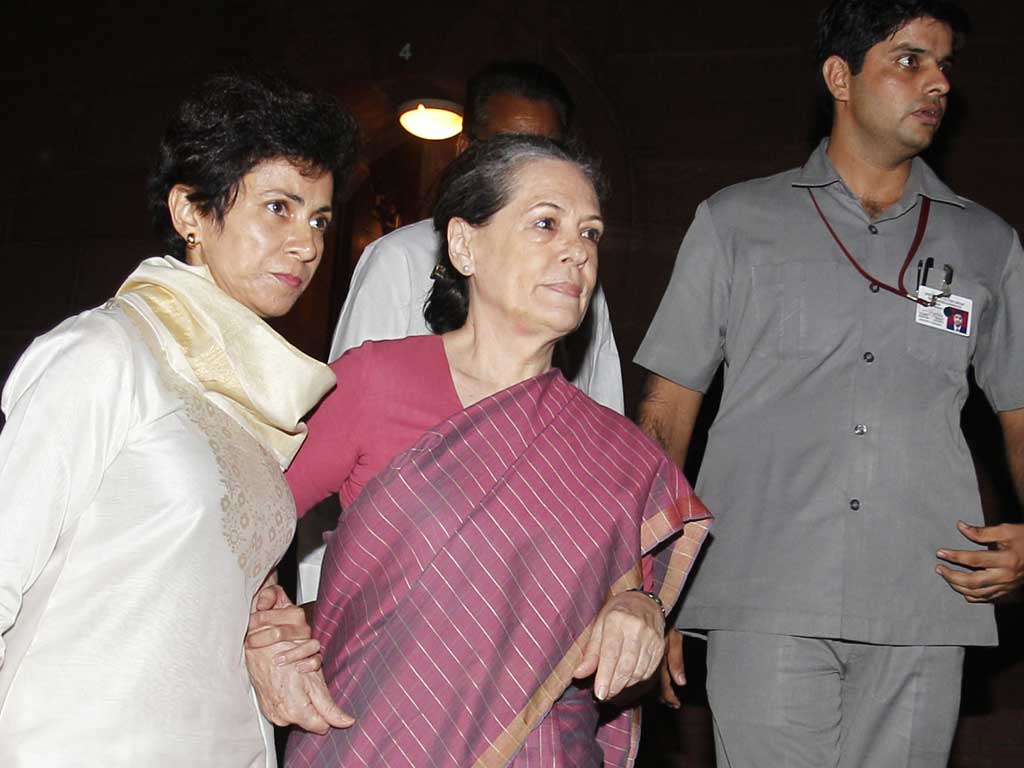 Sonia Gandhi (centre) is supported by the Minister of Housing and Urban Poverty Alleviation Kumari Selja (left) as she leaves parliament