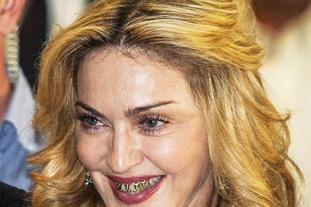 Material Grill: Madonna, wearing a gold grill over her teeth, pictured at a 'Hard Candy' gym launch