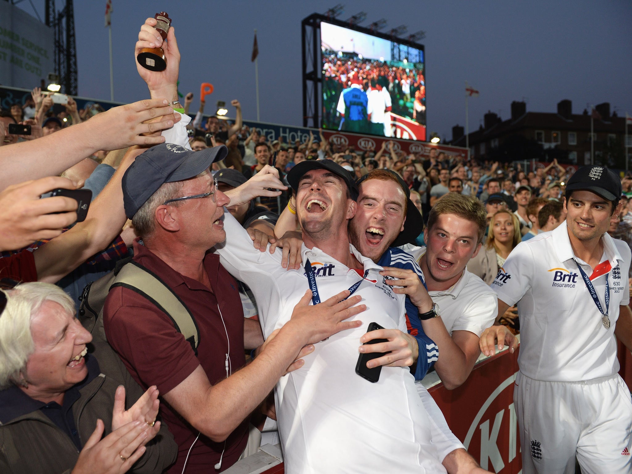 Kevin Pietersen and Alastair Cook of England celebrate with fans after England won the Ashes