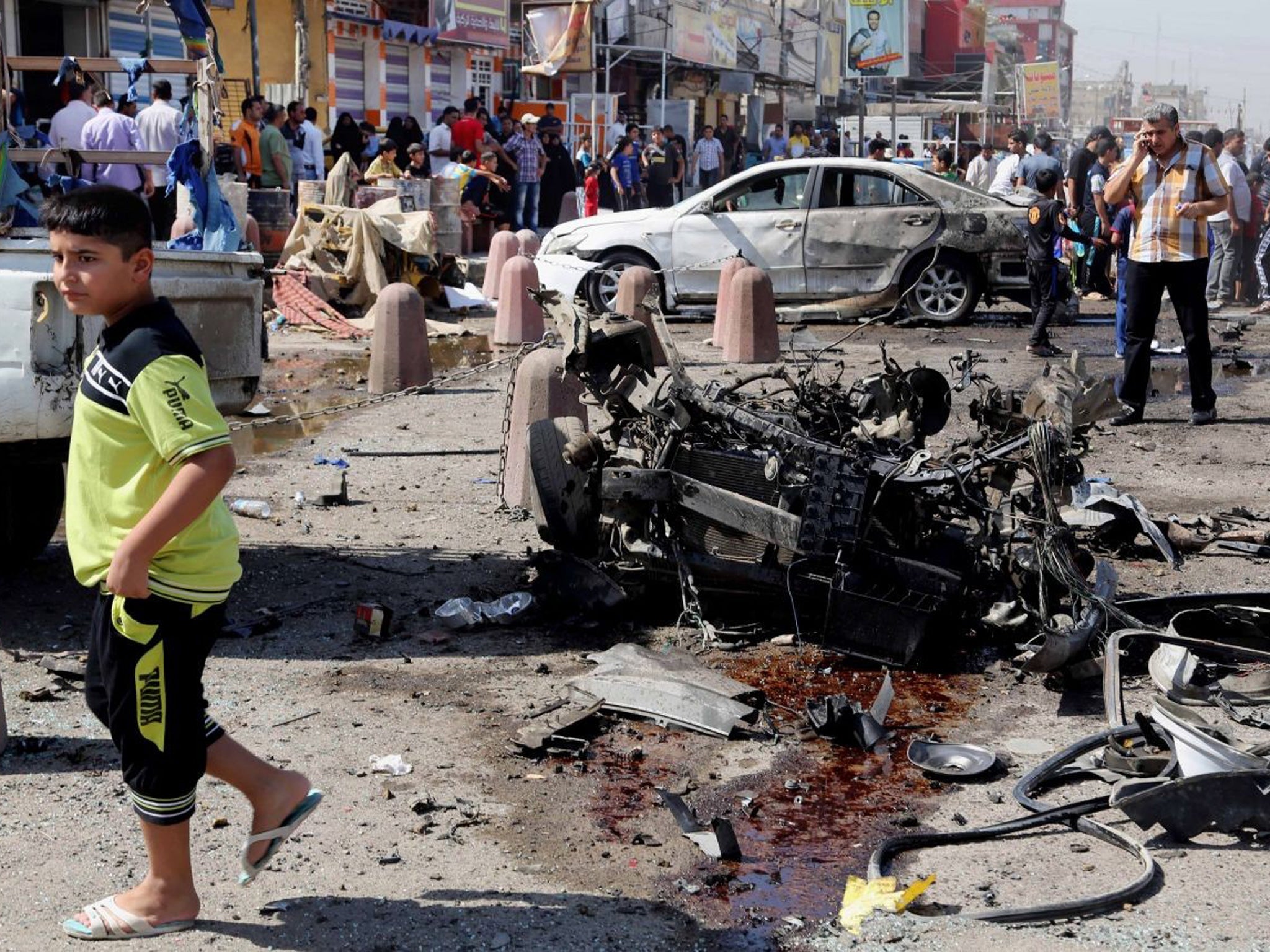 People inspect the site of a car bomb attack in Sadr City, Baghdad, as a co-ordinated wave of bombings tore through Shia Muslim areas in and around the Iraqi capital