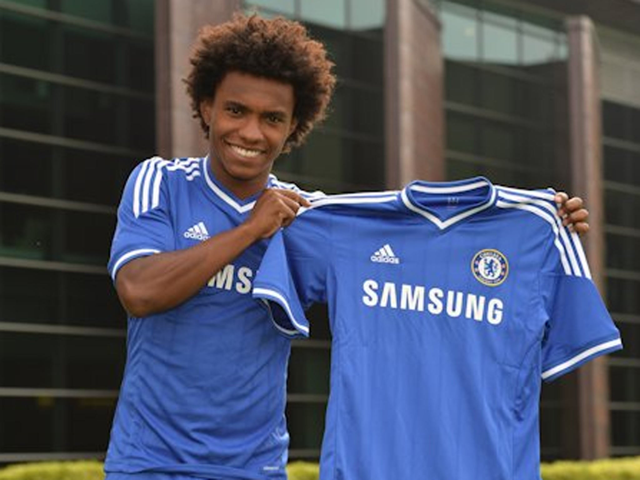 Willian poses with a Chelsea shirt