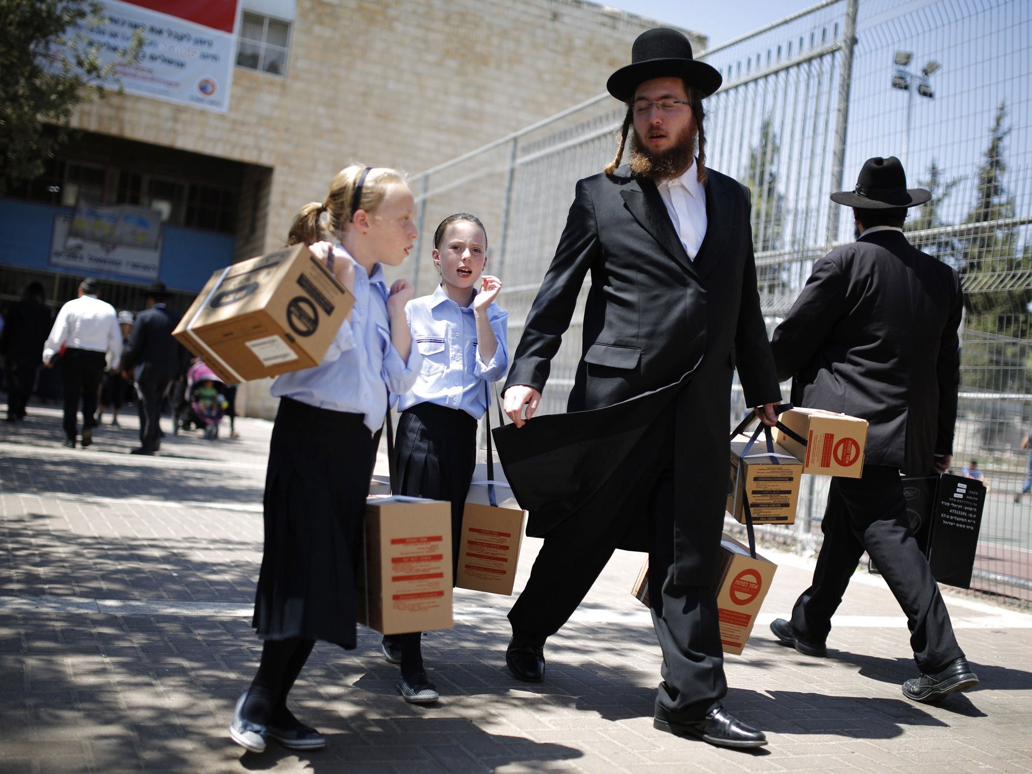 An Orthodox Jew and his children collect gas masks in Jerusalem