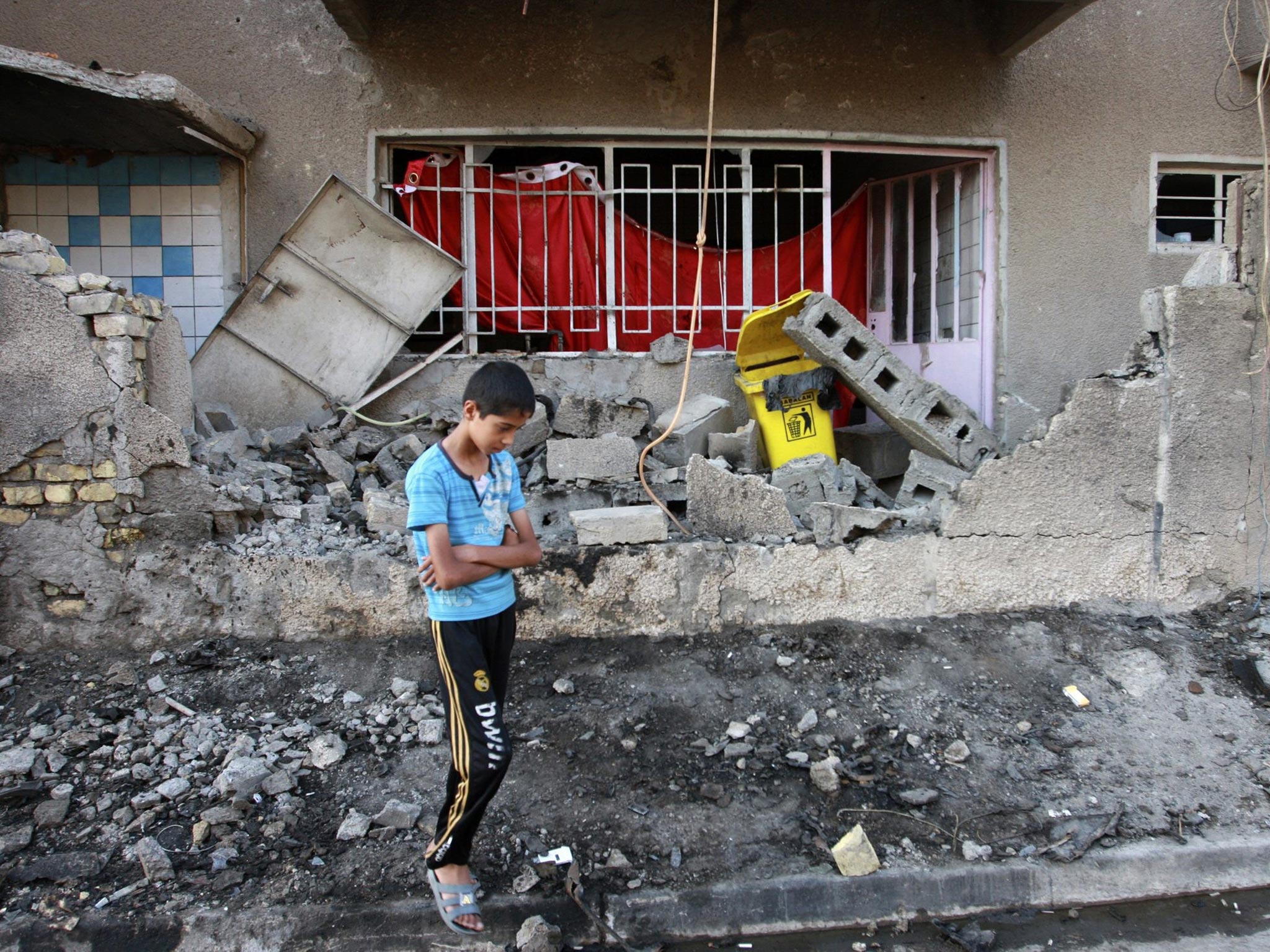 A child stands at the site of a car bomb attack in Baghdad, earlier this year