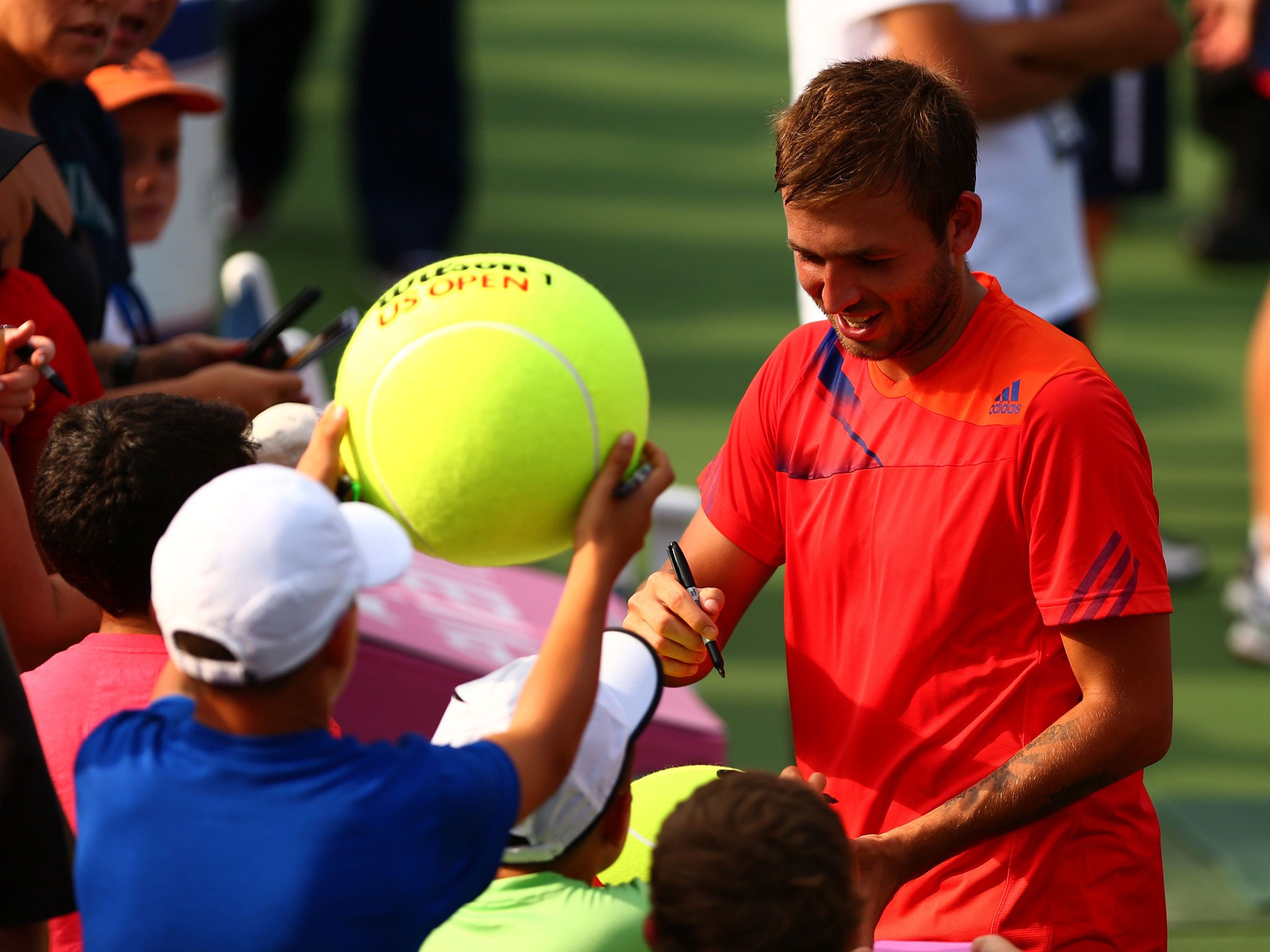 Dan Evans signs autographs after his shock victory over Bernard Tomic in New York