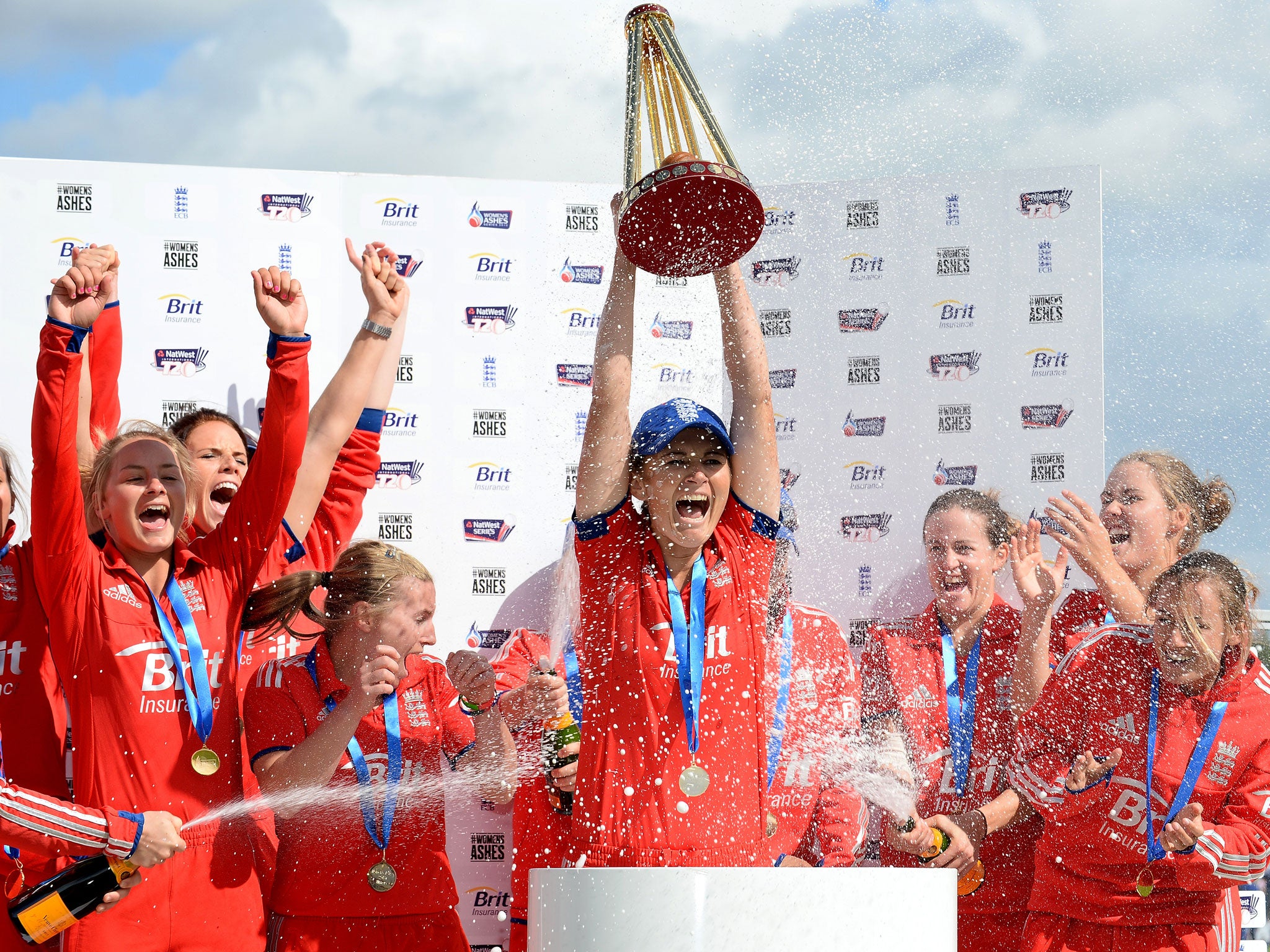 England's Charlotte Edwards (C) lifts the Ashes trophy as she celebrates with her teammates