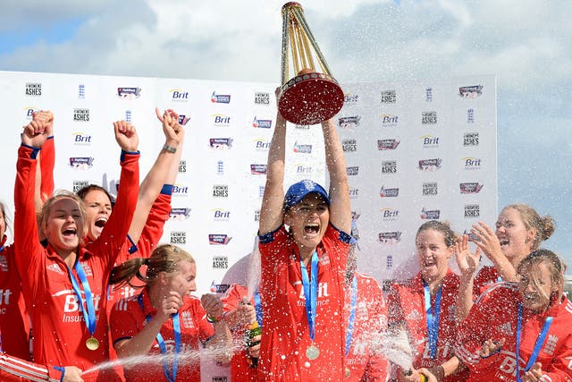 England's Charlotte Edwards (C) lifts the Ashes trophy as she celebrates with her teammates