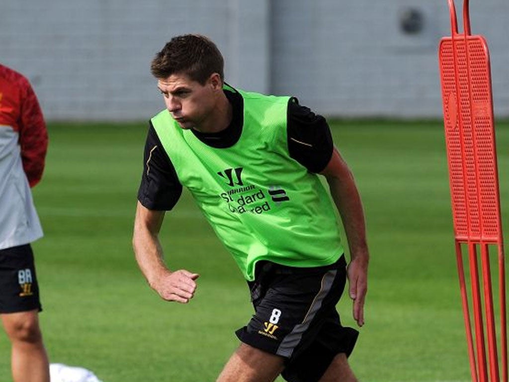 Work to do: Steven Gerrard trains under the watchful eye of his manager Brendan Rodger