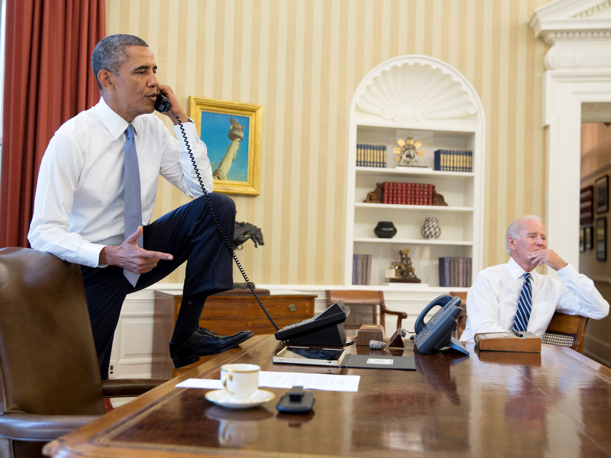 President Barack Obama talks on the phone as Vice President Joe Biden listens in, August 31, 2013.