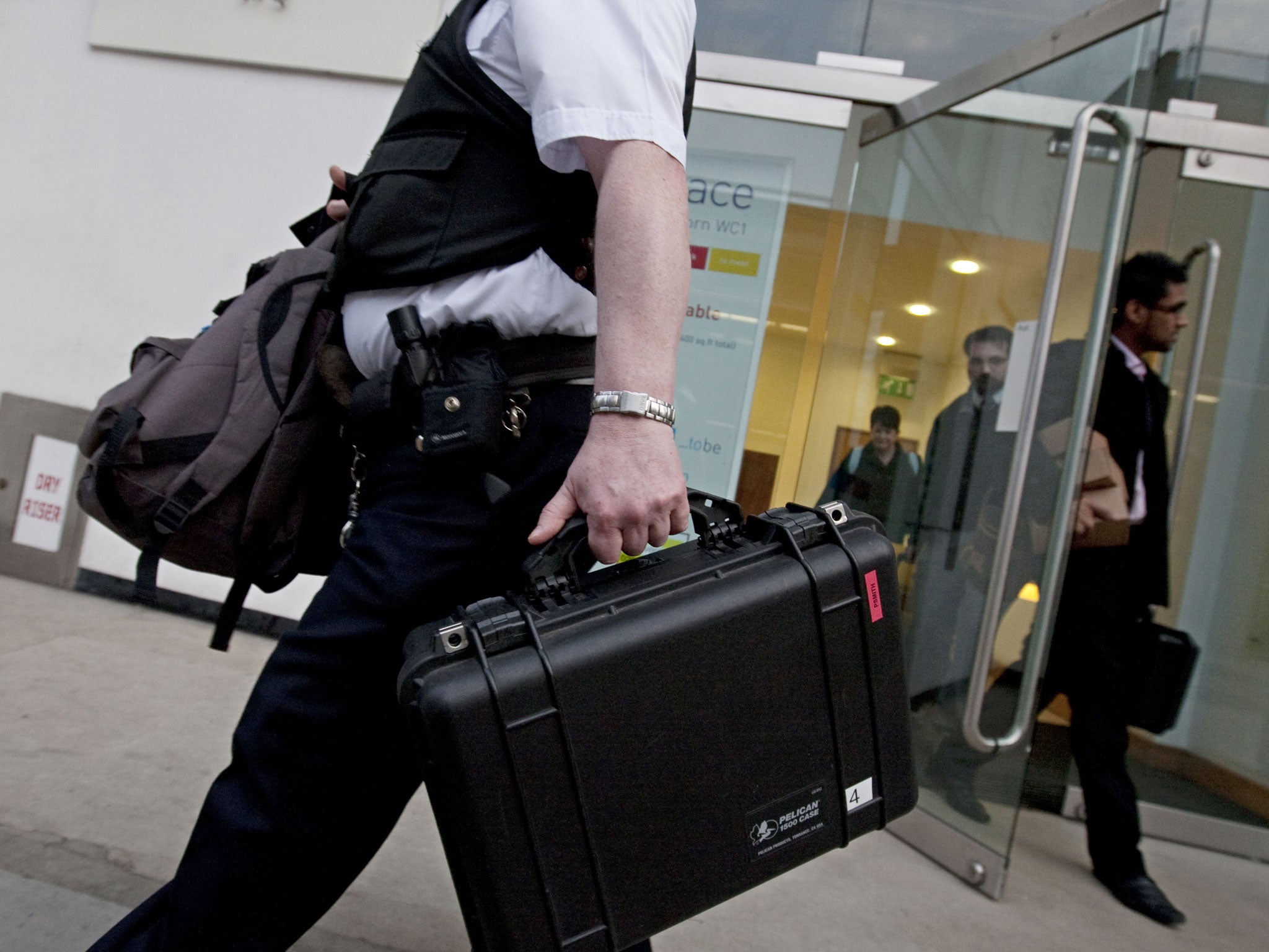 A police officer leaves the London office of French engineering group Alstom, on March 24, 2010. Three members of the board were arrested after investigation by the SFO